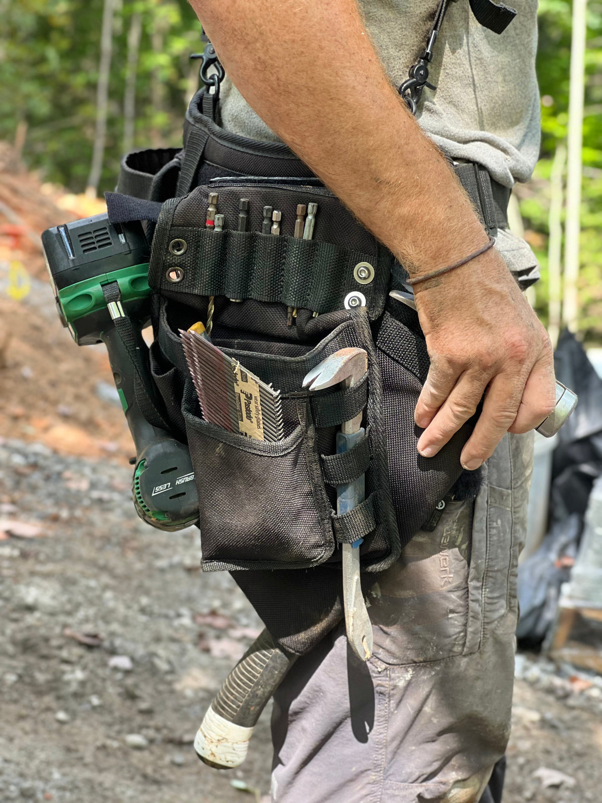 Builder nailing off a floor deck in a Perkins toolbelt and suspenders